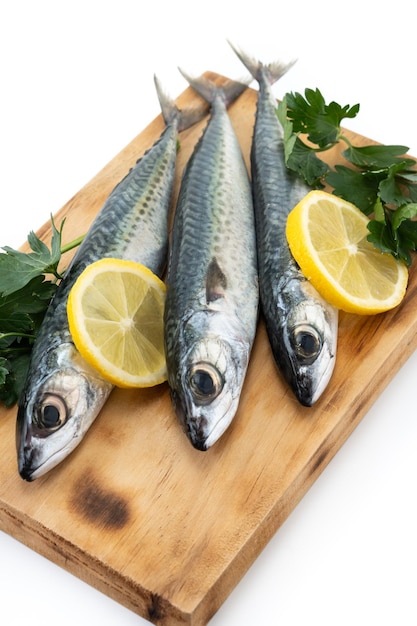 Raw mackerel fish on cutting board isolated on white background