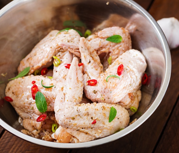 Foto gratuita ali di pollo marinate crude preparate in stile asiatico con miele, aglio, salsa di soia ed erbe