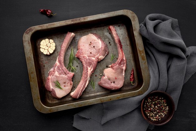 Raw meat in baking pan on table