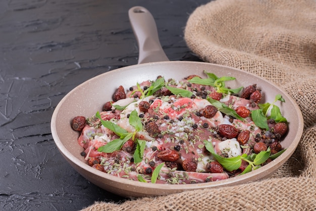 Raw meat salad with fresh mint in pan.