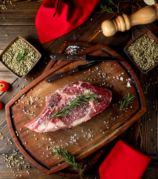 Raw meat slice topped with herbs and salt
