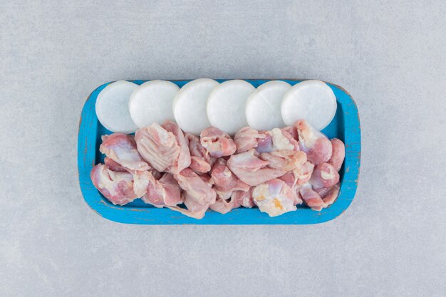 Raw meat in the tray, on the marble surface