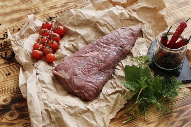 Carne cruda con ingredienti per cucinare il pasto