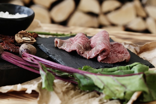 Carne cruda con ingredienti per cucinare il pasto