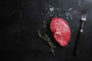 Foto gratuita carne cruda con spezie ed erbe aromatiche in tavola