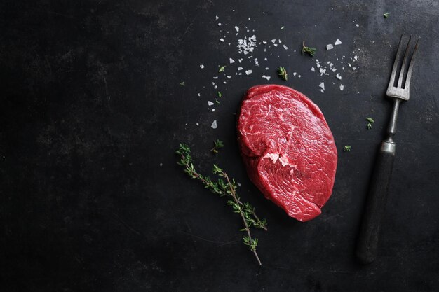 Raw meat with spices and herbs on table