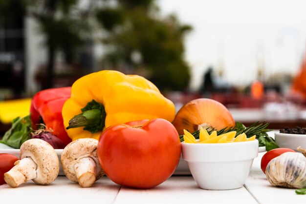 Raw mushrooms; tomato; bell peppers; garlic; onion; on white desk