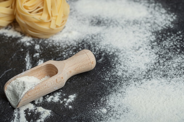 Raw nest noodles with flour on black.