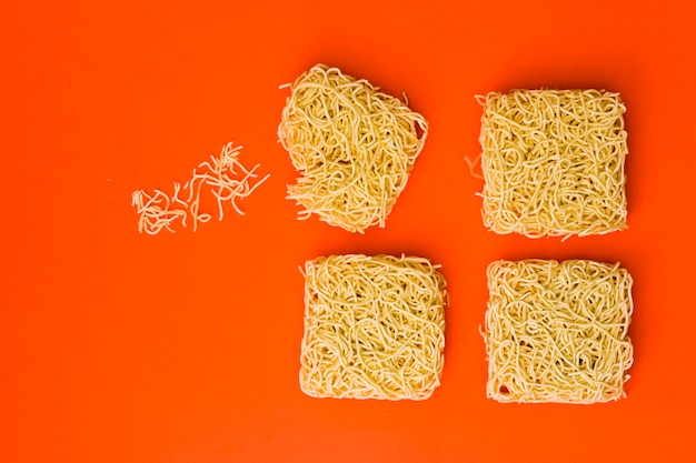 Raw noodles arranged over bright color surface