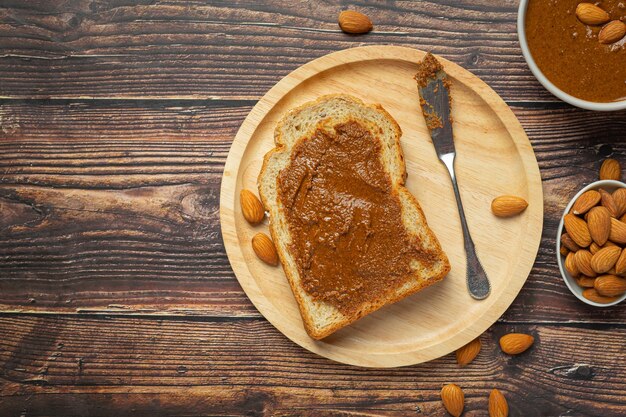 Raw Organic Almond Butter on dark wood background