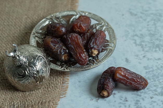 Raw organic dates on glass saucer.