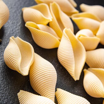 生​パスタコンキリエ​貝殻​は​、​テーブル​の​上​の​成分​健康的​な​食事​食品​スナック​を​形成します