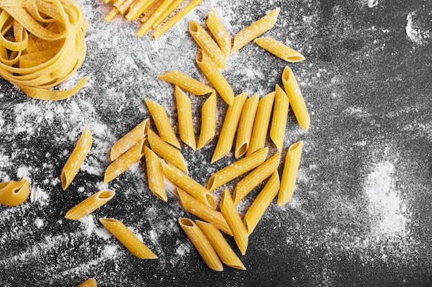 Raw pasta on a flour covered surface.