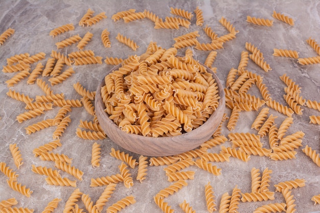 素朴な木製カップと灰色の大理石の生パスタ。