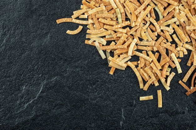 Raw pasta scattered on dark surface. High quality photo