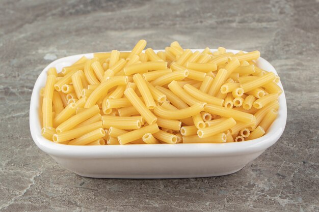 白いボウルに細いチューブのような形をした生パスタ。