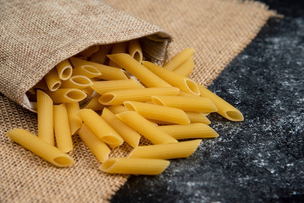 Foto gratuita varietà di pasta cruda su un pezzo di tela.