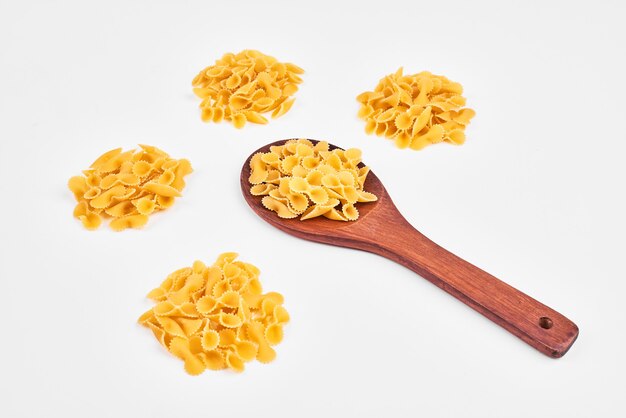 Raw pasta in a wooden spoon.