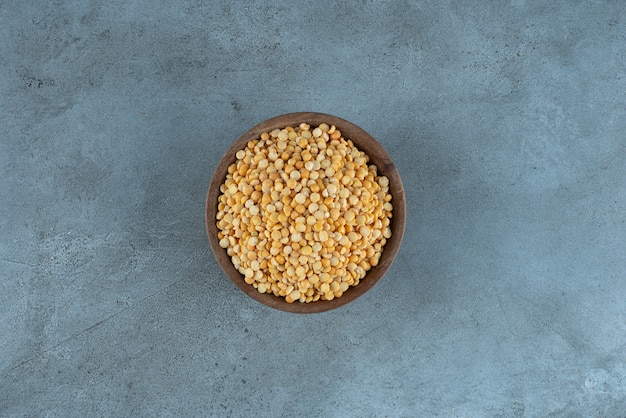 Raw pea beans in a cup on blue background. High quality photo