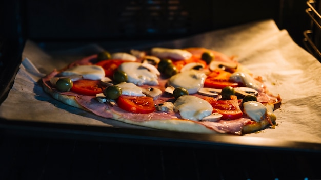 Raw pizza in oven