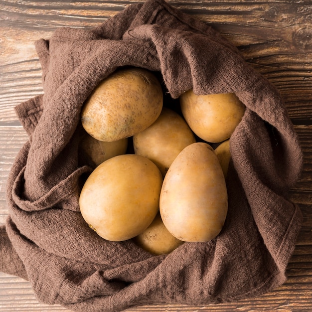 Free photo raw potatoes on brown cloth