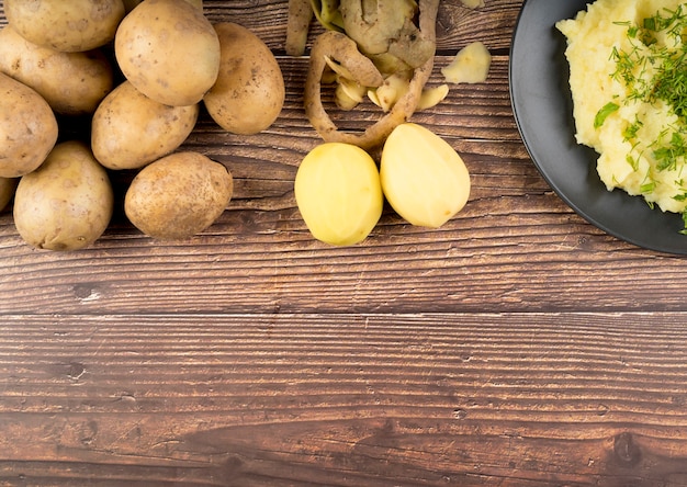 Raw potatoes on wooden background with copy space