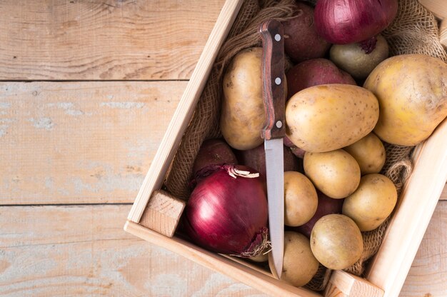 Raw potatoes in wooden box with copy space