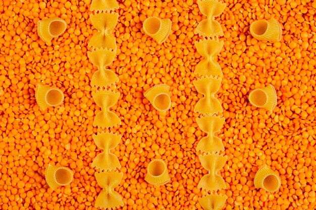 Raw red lentils and farfalle or bow-tie pasta top view