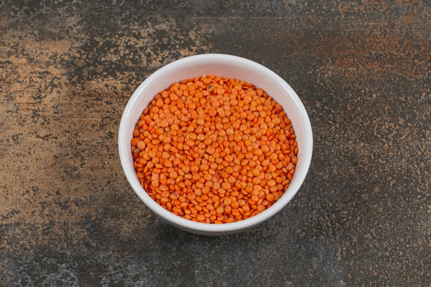 Free photo raw red lentils in white bowl.