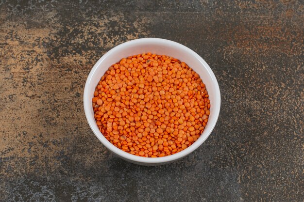 白いボウルに生の赤レンズ豆。