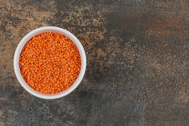 Free photo raw red lentils in white bowl.