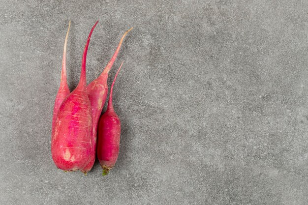 Raw red radishes on marble surface