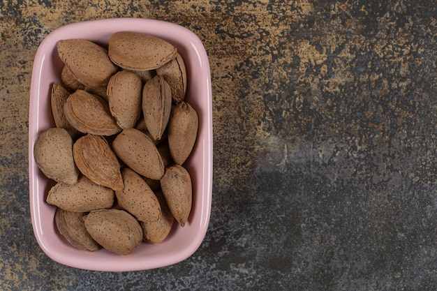 raw-shelled-almonds-pink-plate_114579-54