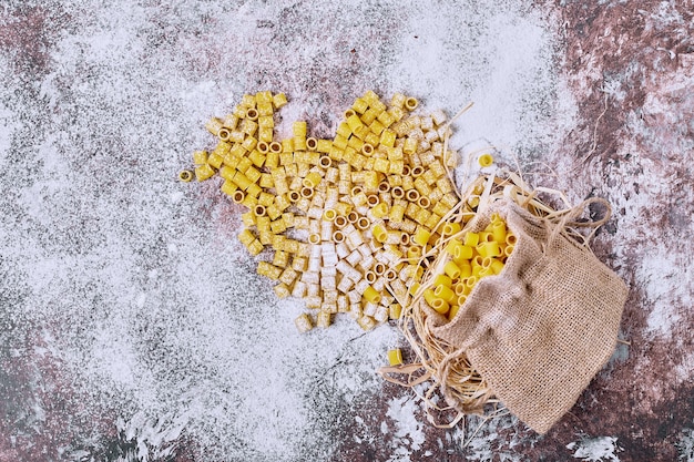 Foto gratuita pasta corta cruda in tela.