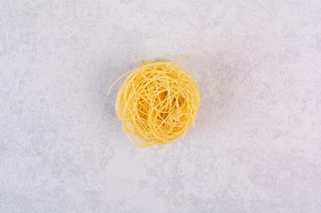 Raw spaghetti nest on stone surface