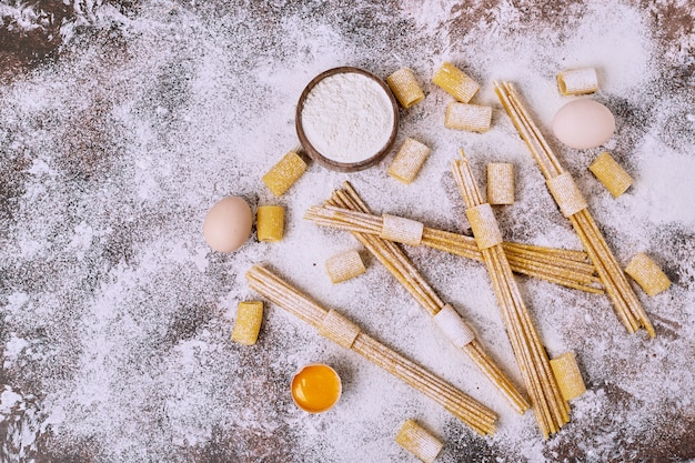 Free photo raw spaghetti over the wooden surface.