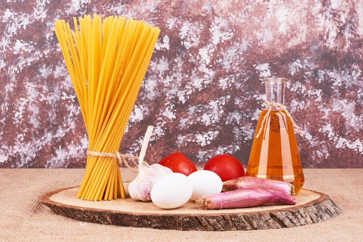 Free Photo raw spaghetties with ingredients on a wooden platter. 