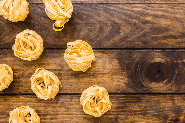 Raw tagliatelle pasta on lumber tabletop