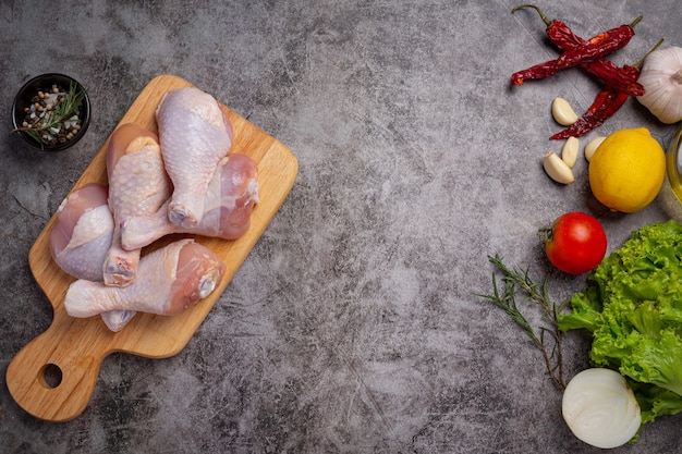 Free photo raw uncooked chicken legs on the dark surface.