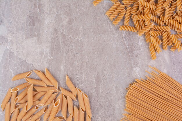 Raw uncooked pastas isolated on the grey space. 