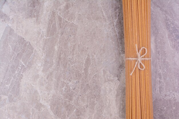 Raw and uncooked pastas isolated on the marble surface