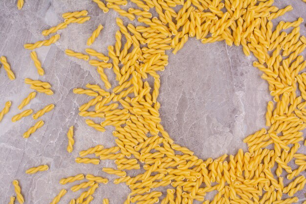 Raw and uncooked pastas isolated on the marble surface