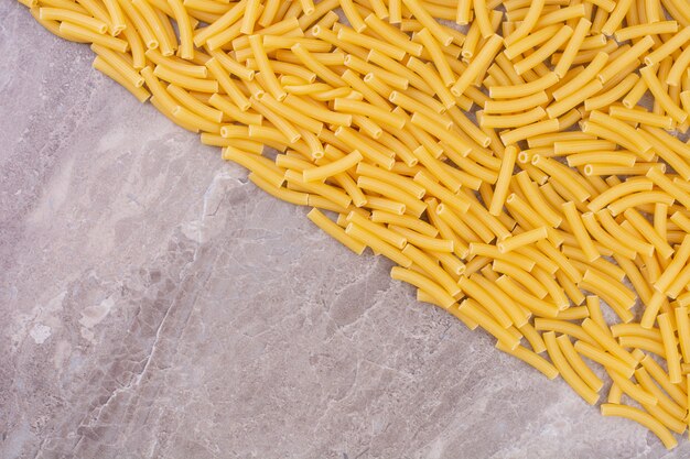 Raw and uncooked pastas isolated on the marble surface