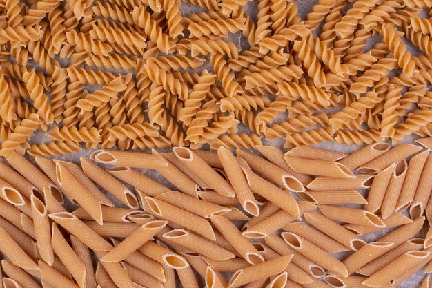 Raw and uncooked pastas isolated on the marble surface