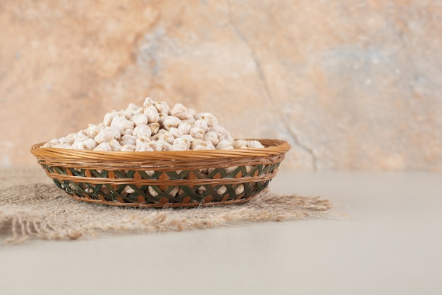 Free photo raw white pea beans on a platter on concrete.