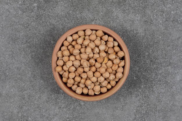 Raw yellow peas in wooden bowl.