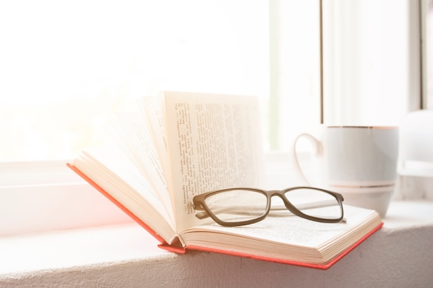 Foto gratuita leggere un libro e bere caffè