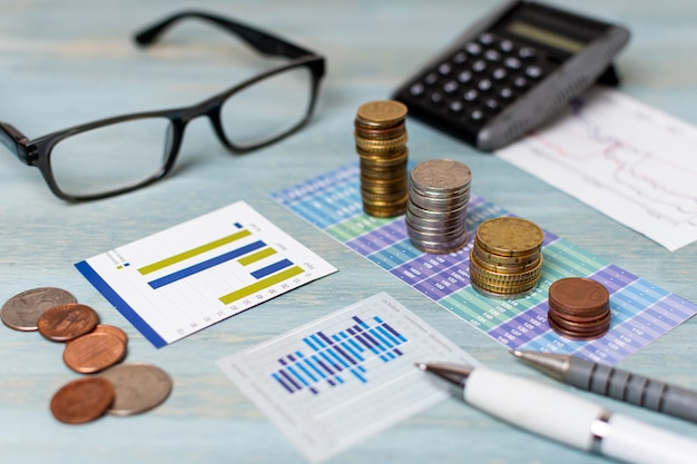 Reading glasses and piles of coins high view