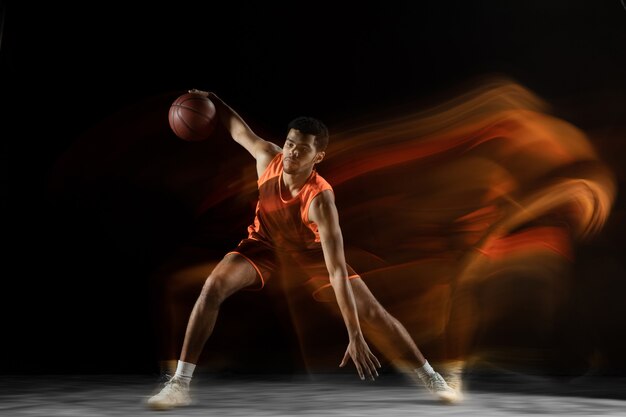 準備。動作中の若いアラビアの筋肉のバスケットボール選手、混合光の中で黒に分離された動き