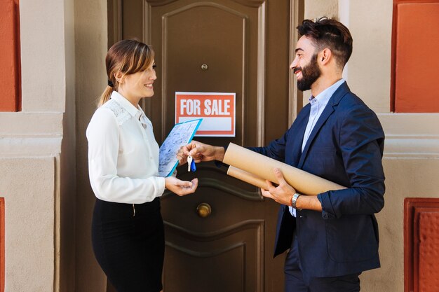 Real estate agent and business woman interchanging keys